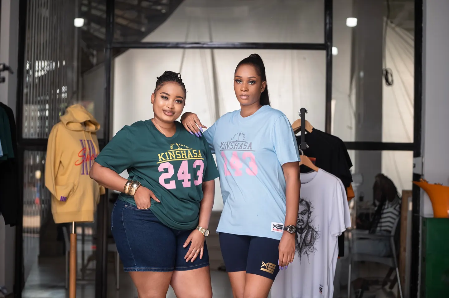 Deux femmes en t-shirts Kinshasa 243, vert et bleu ciel, dans la boutique Match Kwata